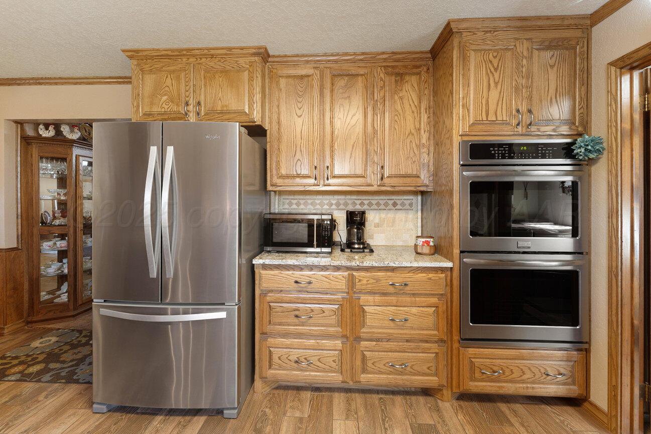 148 Buffalo Trail Fritch, TX 79036 - Photo 15 of 81 a kitchen with granite countertop stainless steel appliances and wooden cabinets