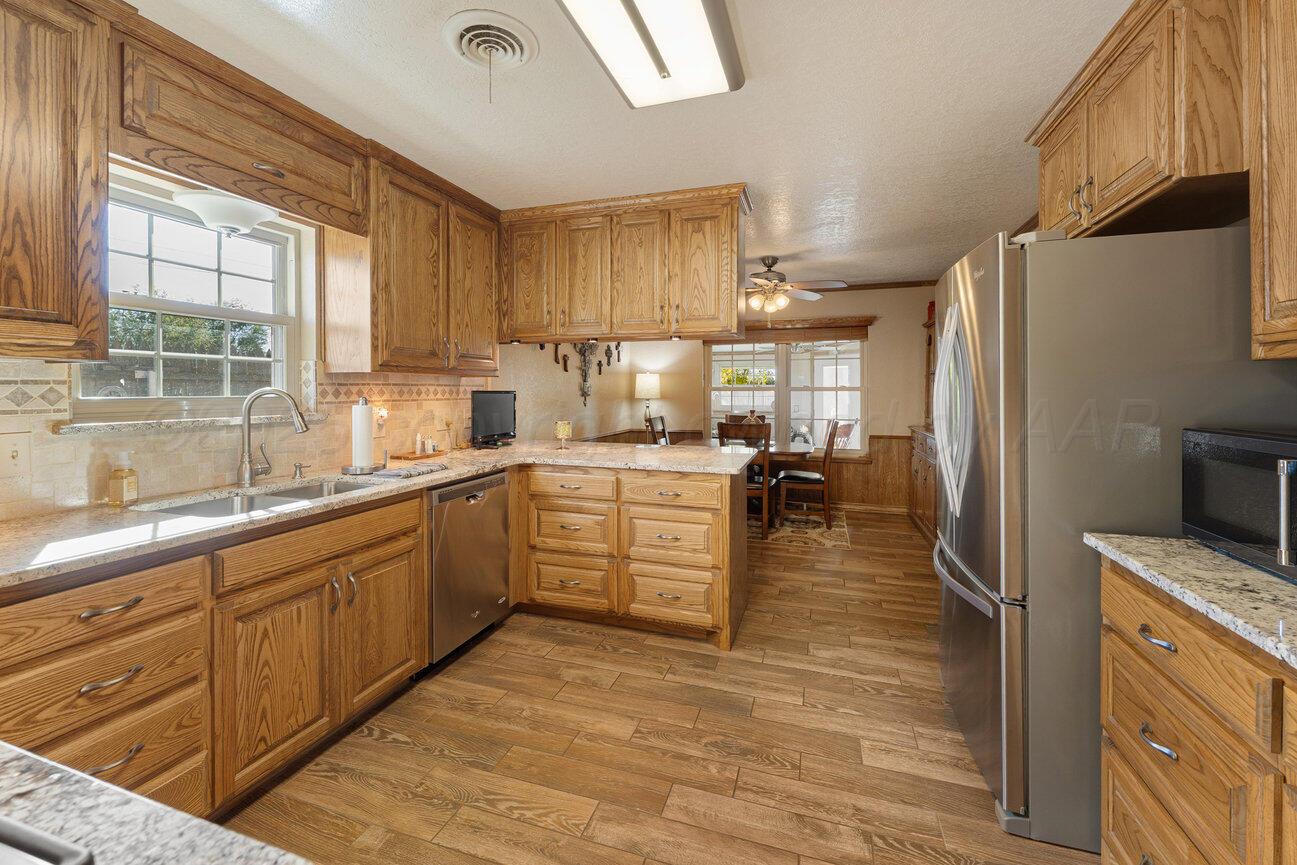 148 Buffalo Trail Fritch, TX 79036 - Photo 16 of 81 a kitchen with stainless steel appliances granite countertop a refrigerator a sink dishwasher a stove and white countertops with wooden floor