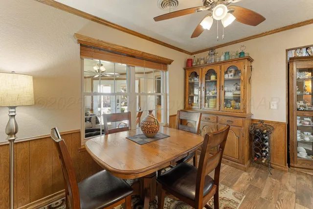 a bedroom with a bed and a dresser with wooden floor