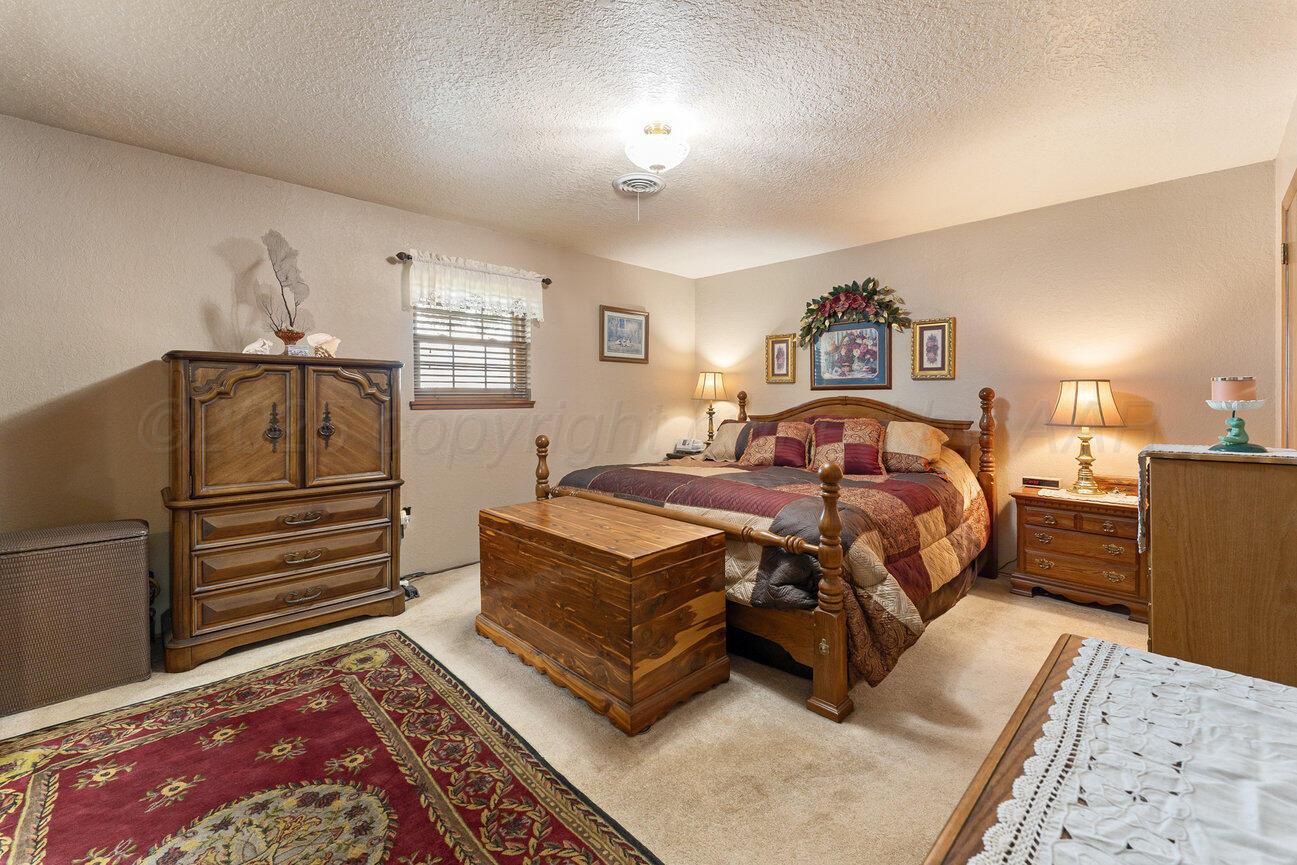 148 Buffalo Trail Fritch, TX 79036 - Photo 27 of 81 a bedroom with a bed and a dresser with wooden floor