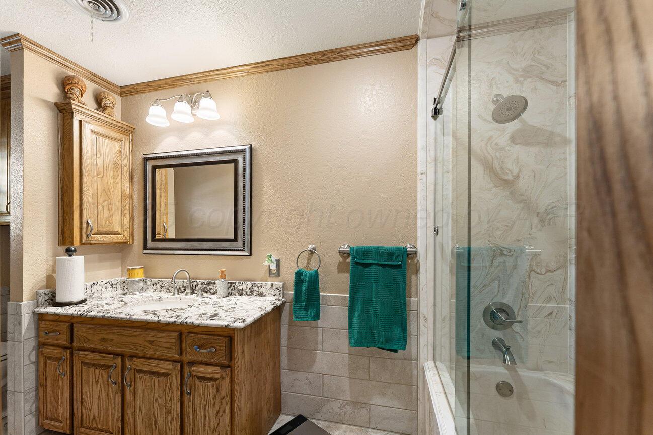 148 Buffalo Trail Fritch, TX 79036 - Photo 34 of 81 a bathroom with a granite countertop sink mirror and shower