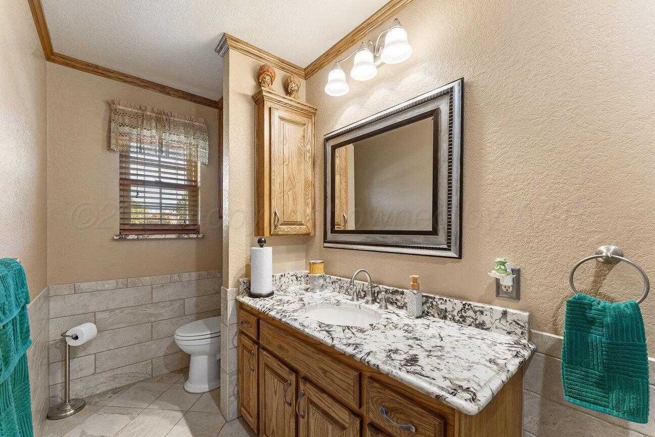 148 Buffalo Trail Fritch, TX 79036 - Photo 35 of 81 a bathroom with a granite countertop sink and a mirror