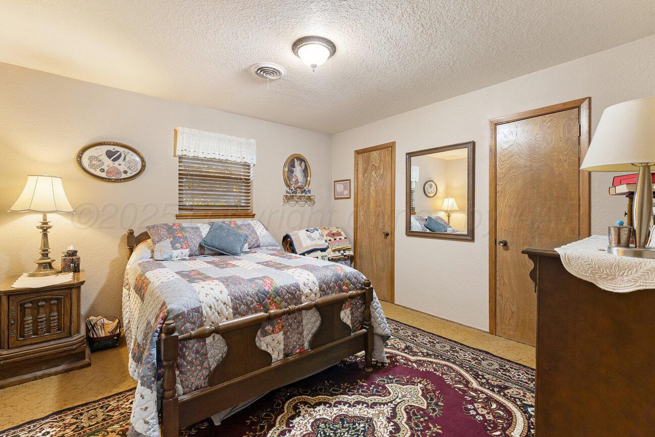 148 Buffalo Trail Fritch, TX 79036 - Photo 37 of 81 a bedroom with a bed and a table in it