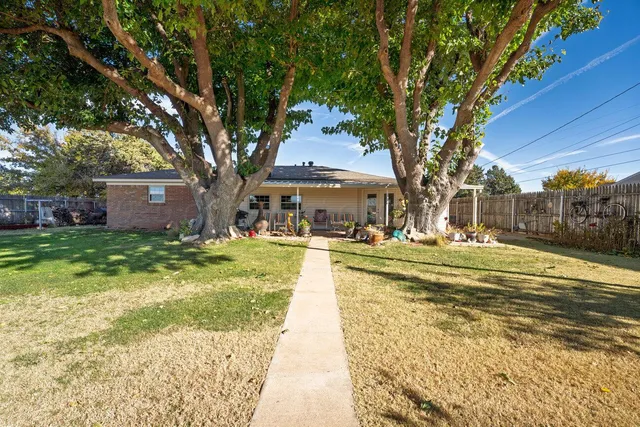 an aerial view of a house with a yard and lake view in back