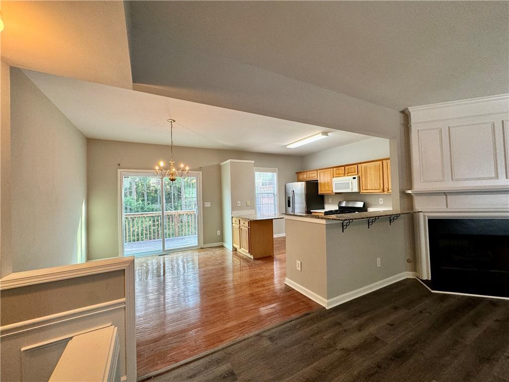 3980 Howell Park Road Duluth, GA 30096 - Photo 11 of 34 a kitchen with granite countertop a stove top oven a sink dishwasher and a fireplace with wooden floor