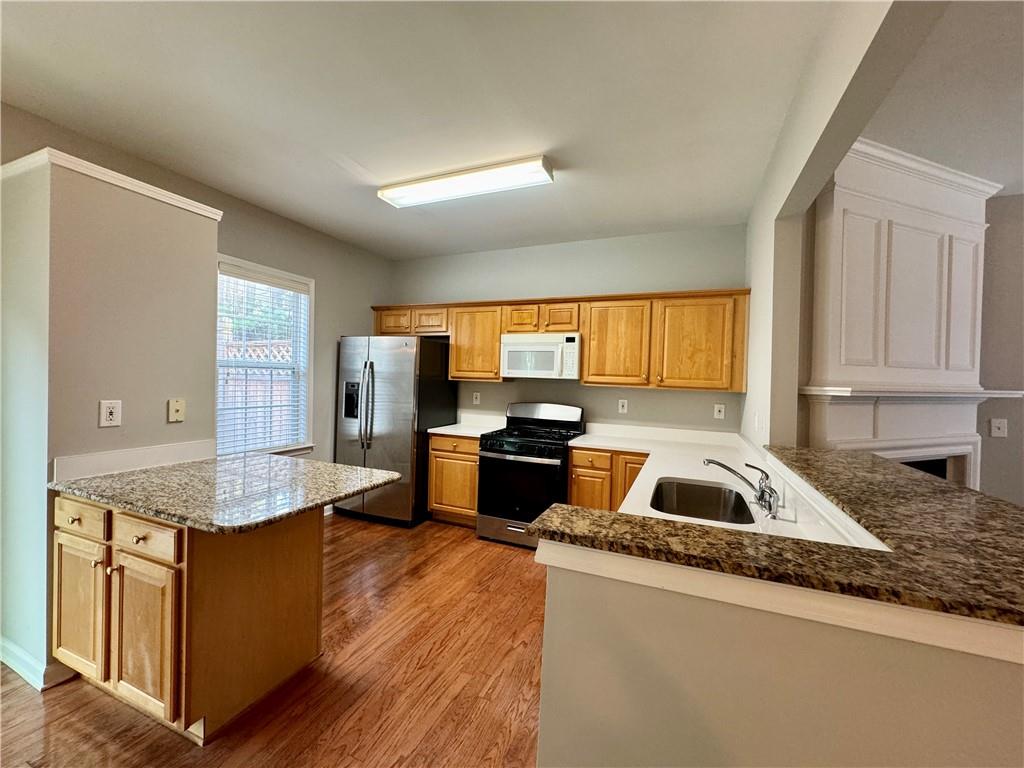 3980 Howell Park Road Duluth, GA 30096 - Photo 17 of 34 a kitchen with granite countertop kitchen island stainless steel appliances a sink stove and refrigerator