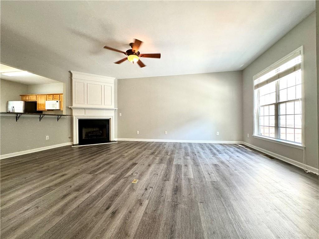 3980 Howell Park Road Duluth, GA 30096 - Photo 8 of 34 an empty room with wooden floor fireplace and windows