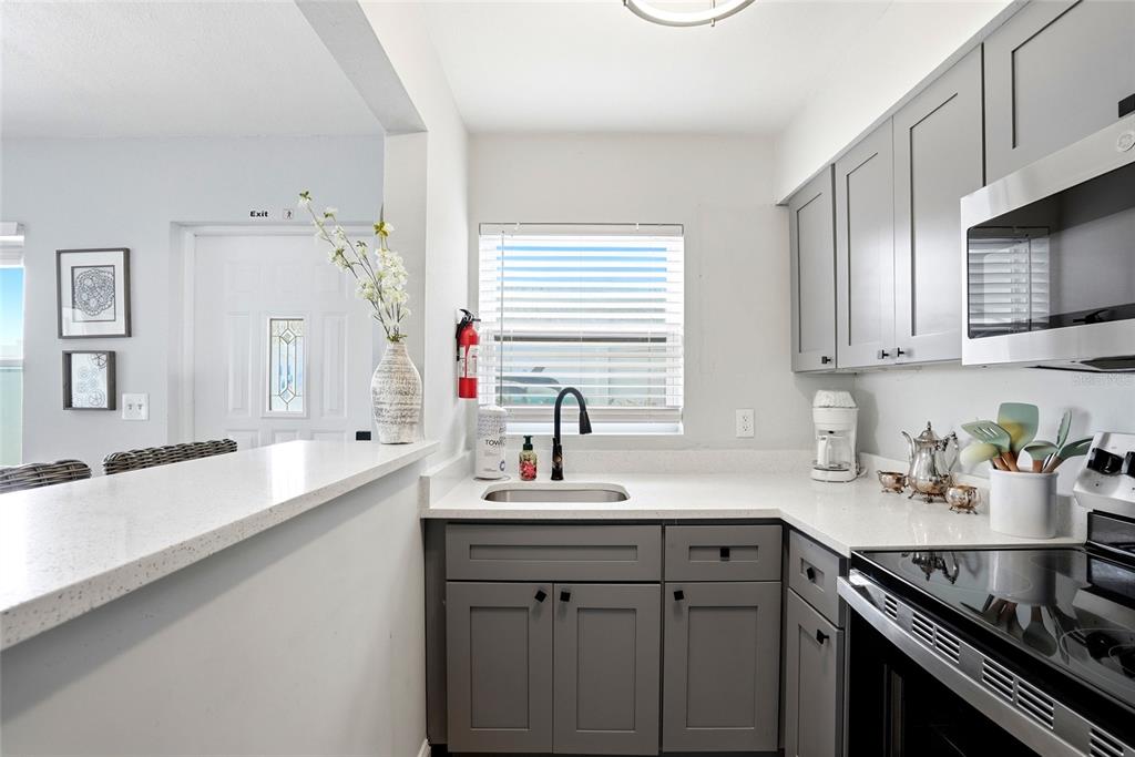 2311 Bay Boulevard Indian Rocks Beach, FL 33785 - Photo 25 of 80 a kitchen with stainless steel appliances granite countertop a sink stove and cabinets
