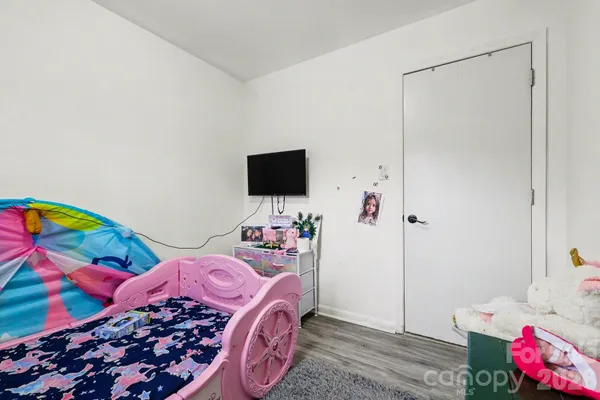 a bedroom with a bed and a flat screen tv