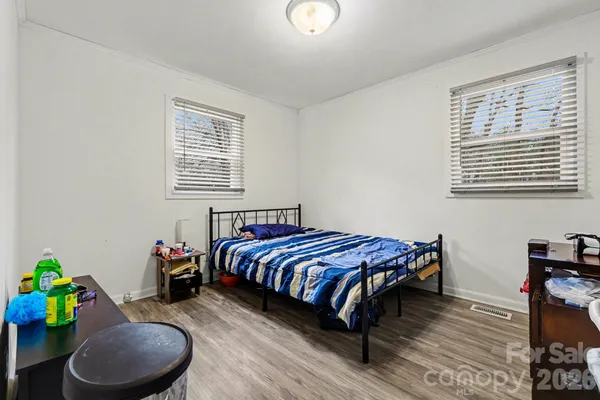 a bedroom with a bed a chandelier and a window