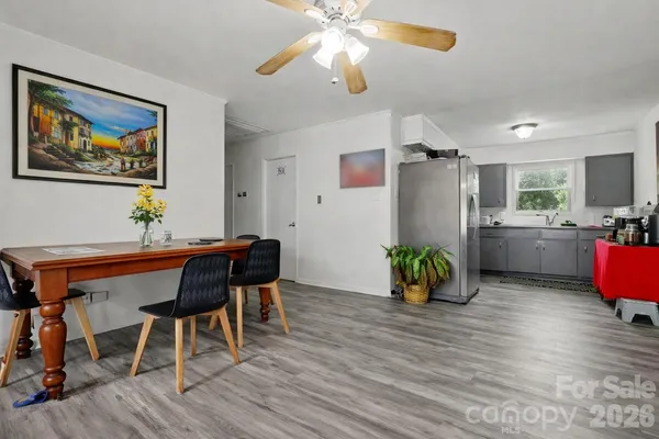 a view of a dining room with furniture a chandelier and wooden floor