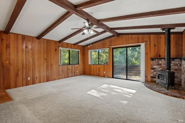 a view of an empty room with furniture and windows