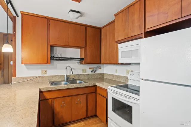 a kitchen with stainless steel appliances granite countertop a sink stove and microwave