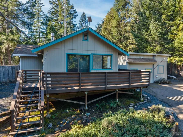 a backyard of a house with wooden deck and furniture