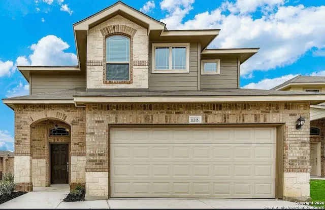 a front view of a house with plants