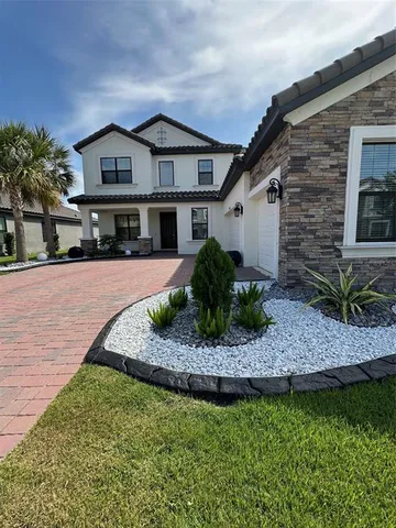 a front view of a house with a garden and plants