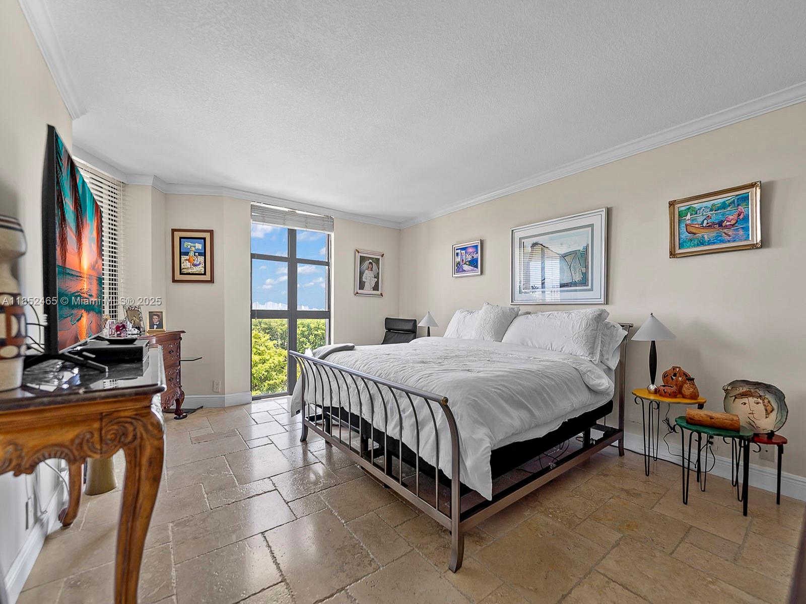 1000 Quayside Terrace, Unit 706 Miami, FL 33138 - Photo 12 of 33 a spacious bedroom with a bed and a table in it