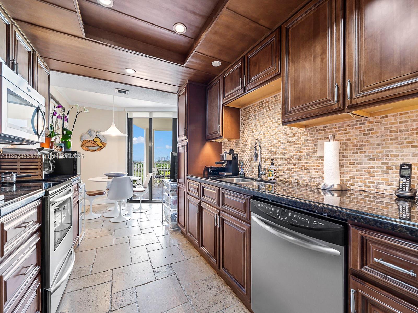 1000 Quayside Terrace, Unit 706 Miami, FL 33138 - Photo 9 of 33 a kitchen with stainless steel appliances a sink stove and cabinets