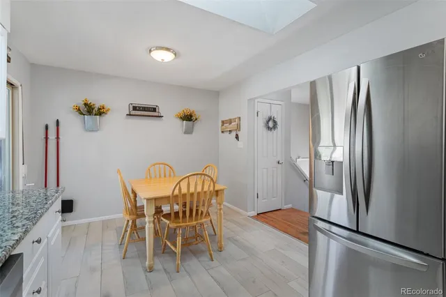 a dining room with furniture and a refrigerator