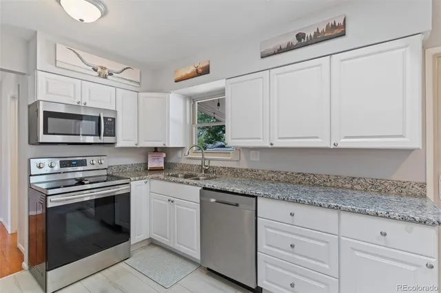 a kitchen with white cabinets stainless steel appliances and sink