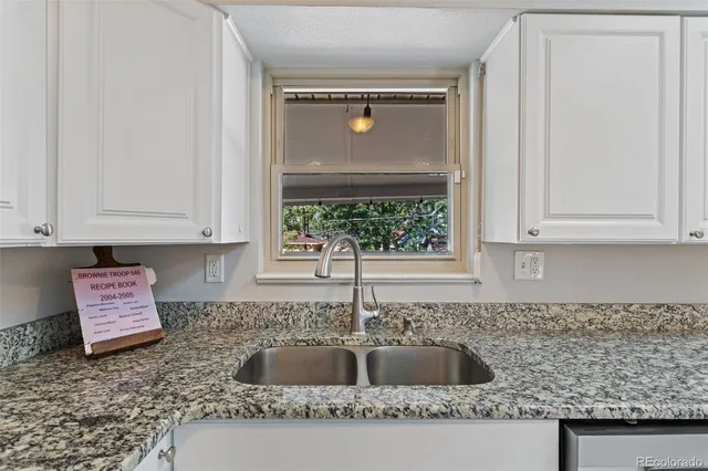 a kitchen with granite countertop a sink and a stove