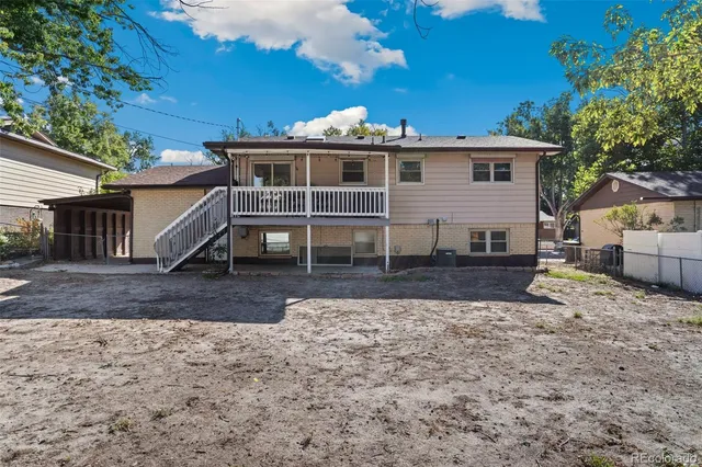 a view of a house with backyard and trees
