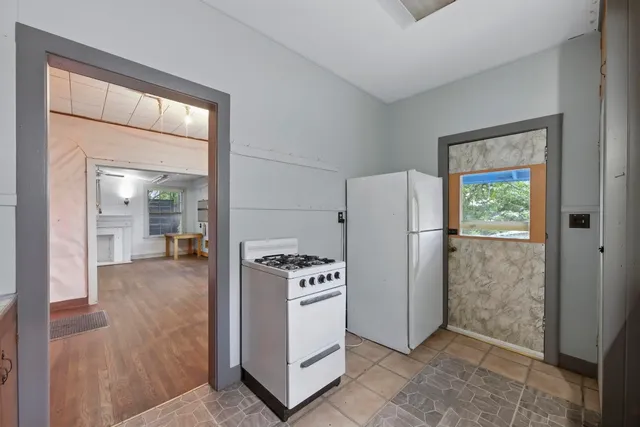 a view of kitchen with furniture refrigerator and window