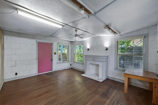 a view of empty room with wooden floor and fireplace
