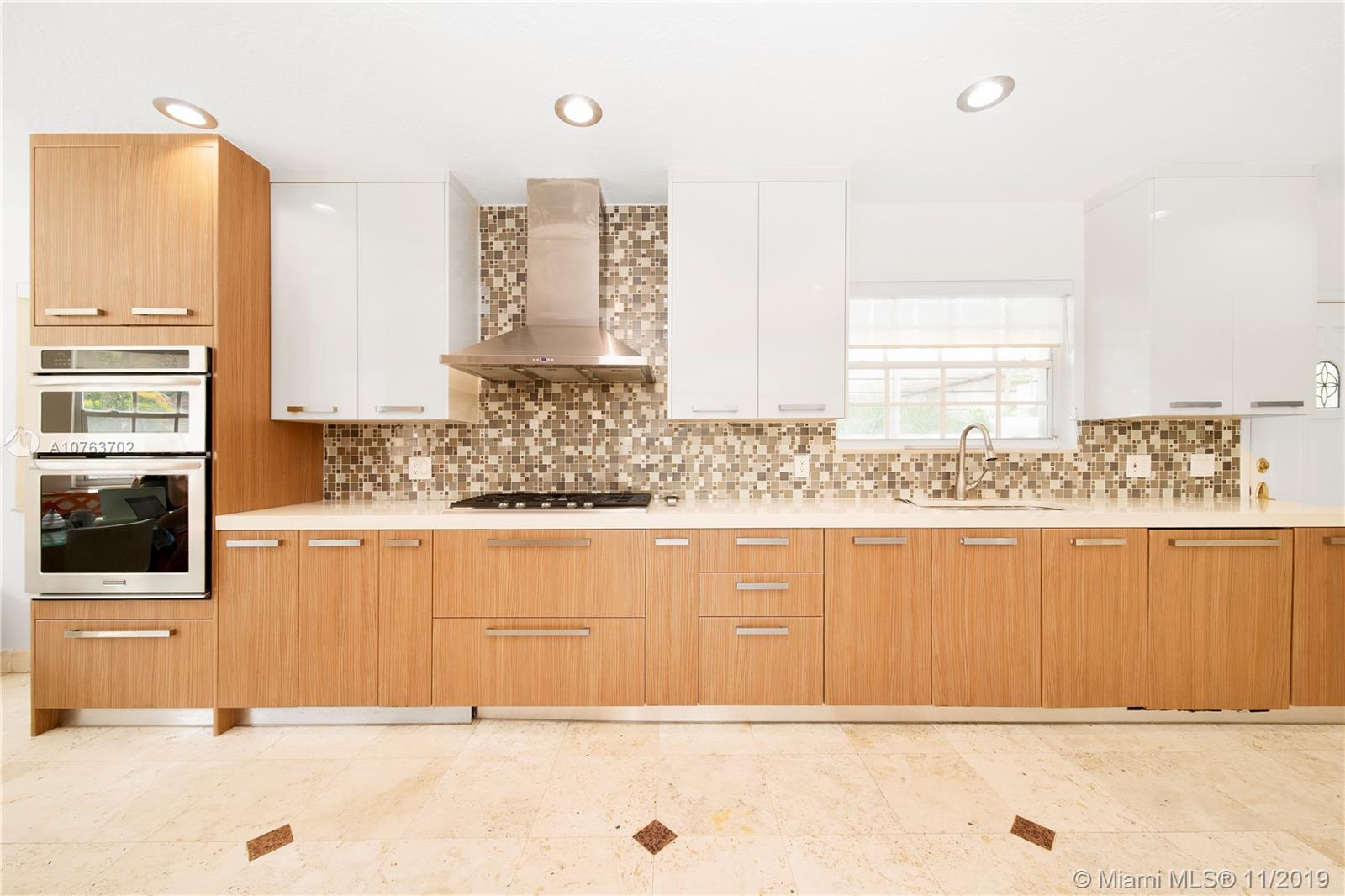 244 Southwest 28th Road Miami, FL 33129 - Photo 13 of 43 a view of a kitchen with stainless steel appliances wooden cabinets and a counter top space