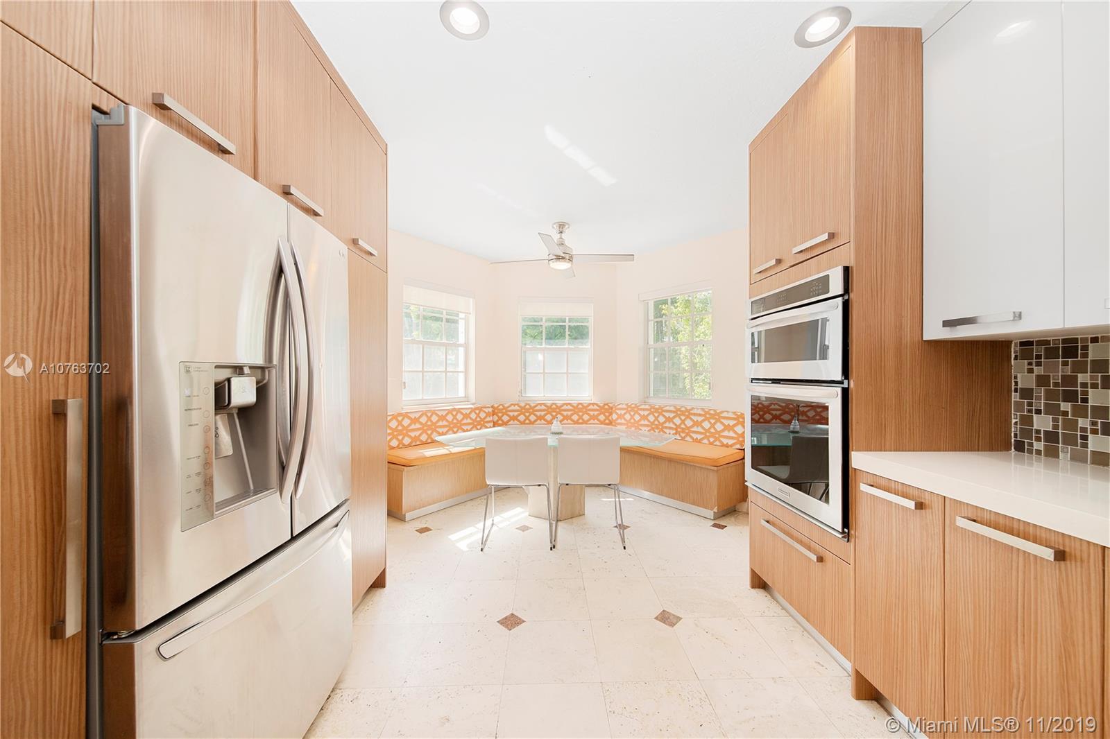 244 Southwest 28th Road Miami, FL 33129 - Photo 16 of 43 a large white kitchen with stainless steel appliances a refrigerator a stove a microwave and cabinets