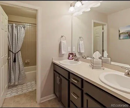 a bathroom with a double vanity sink a mirror and a shower