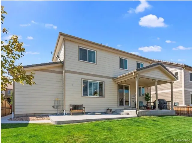 a backyard of a house with table and chairs