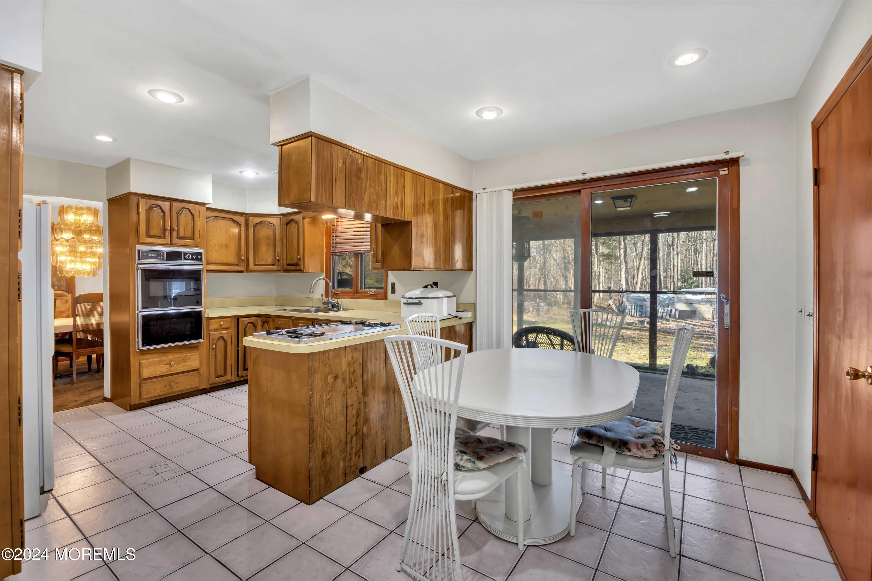 109 Crine Road Morganville, NJ 07751 - Photo 13 of 26 a kitchen with stainless steel appliances a table and chairs in it
