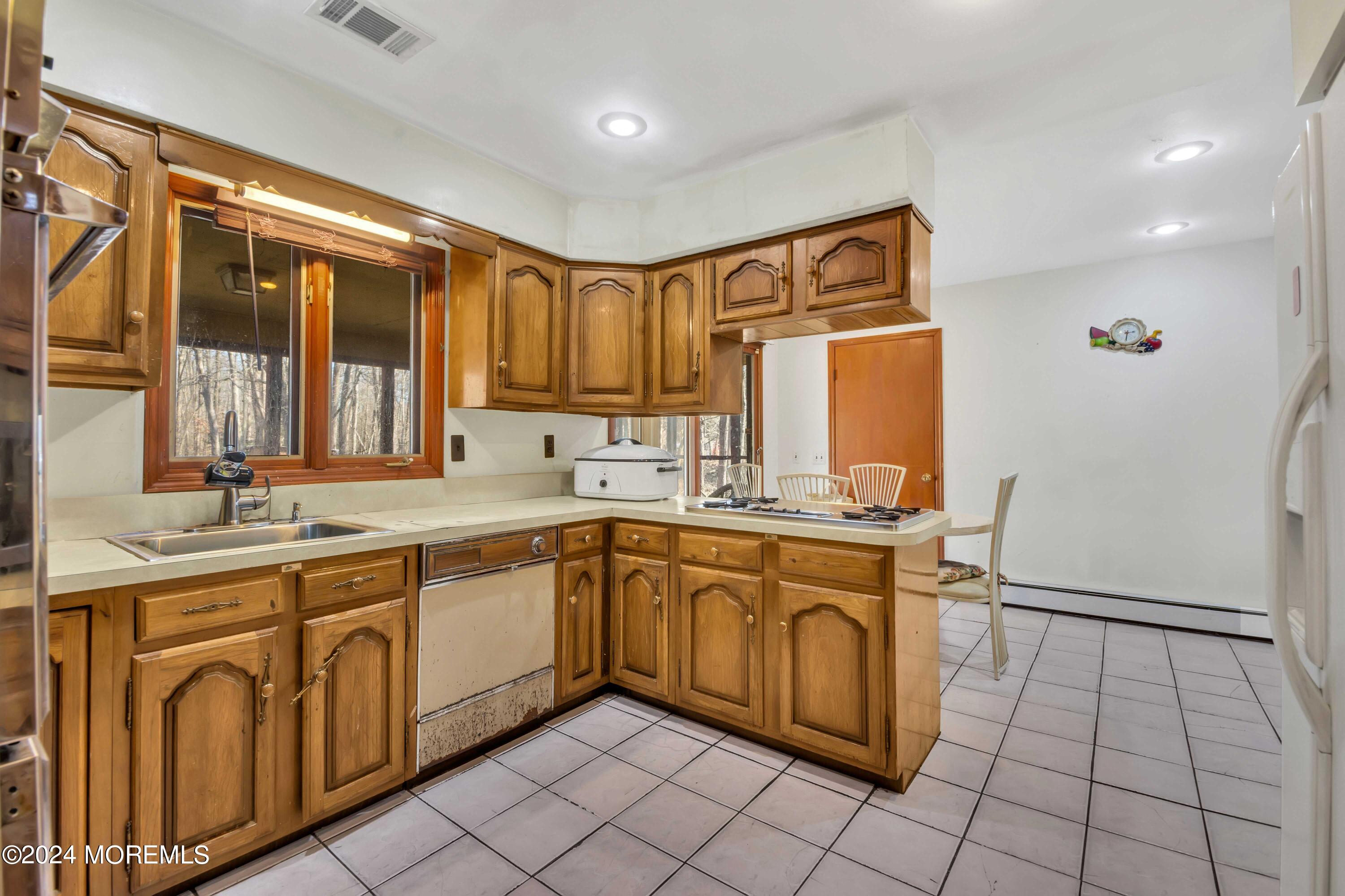 109 Crine Road Morganville, NJ 07751 - Photo 14 of 26 a kitchen with a sink stove and cabinets