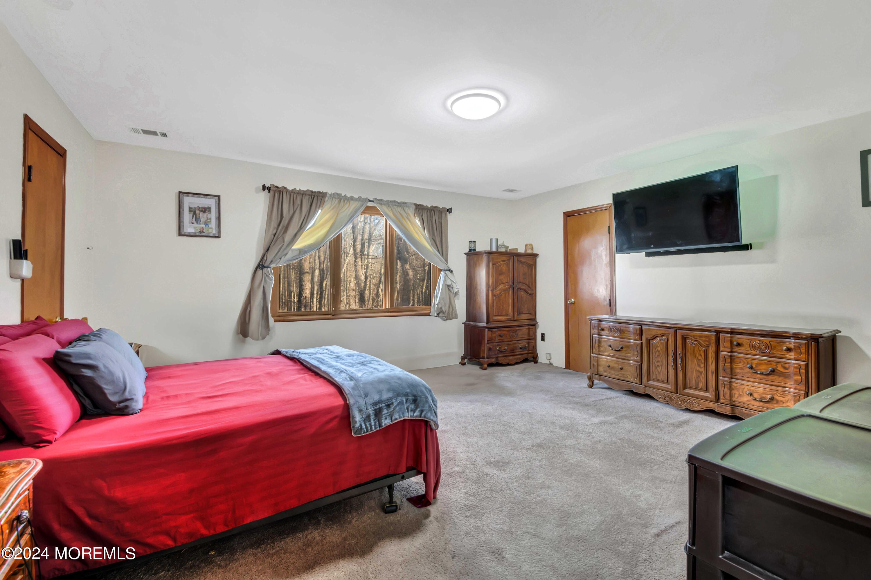 109 Crine Road Morganville, NJ 07751 - Photo 17 of 26 a bedroom with a bed and a flat screen tv