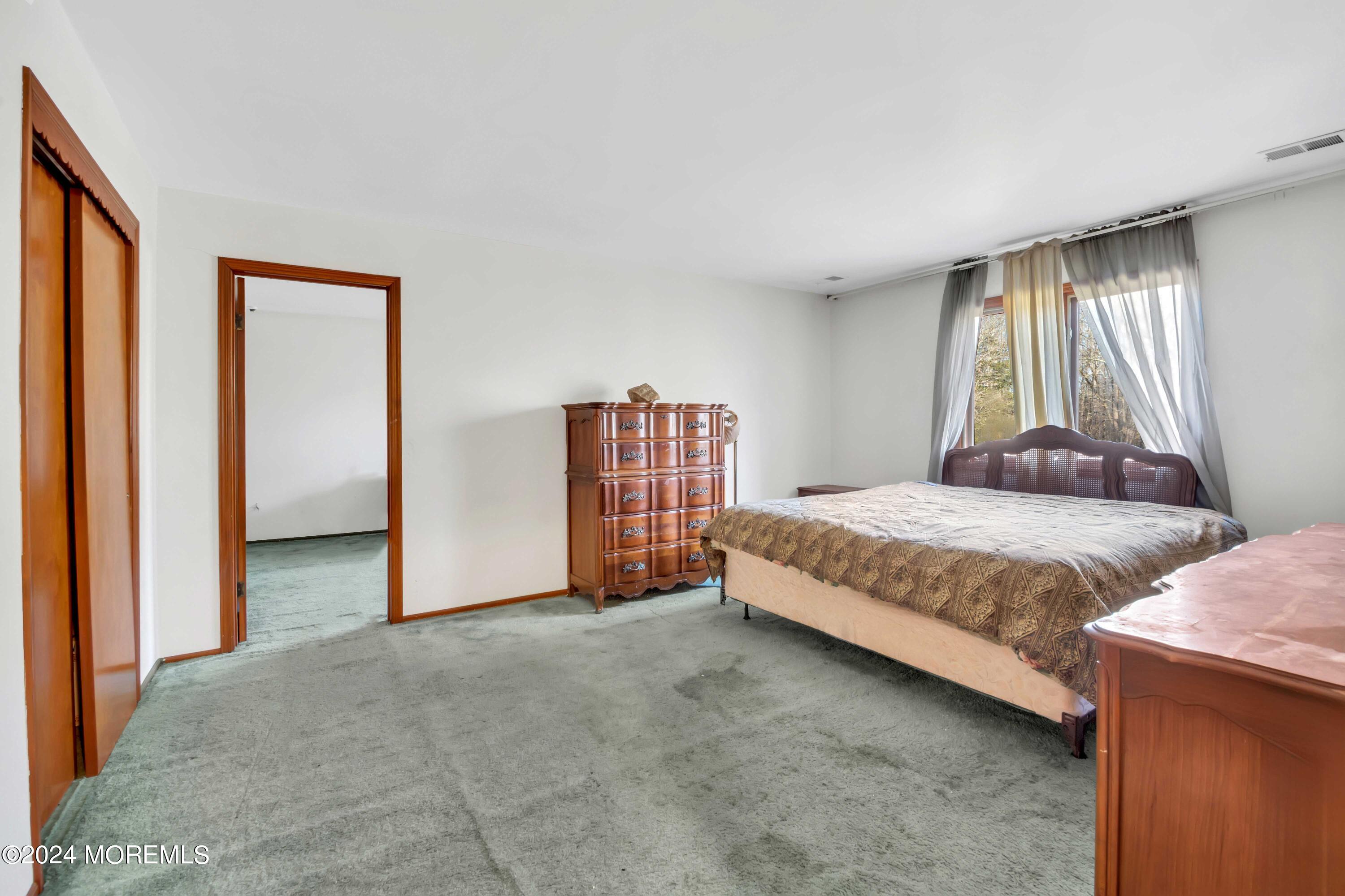 109 Crine Road Morganville, NJ 07751 - Photo 22 of 26 a spacious bedroom with a bed and glass window