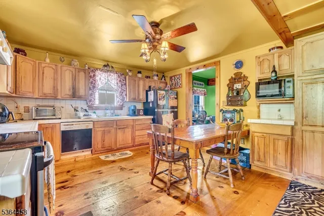 a kitchen with stainless steel appliances kitchen island granite countertop a table chairs and a refrigerator