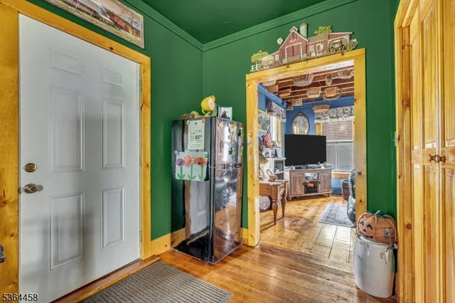 a view of a livingroom with wooden floor and a flat screen tv