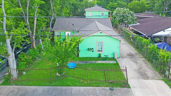 a view of a house with a big yard plants and large trees