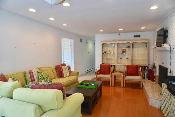a living room with furniture a flat screen tv and a fireplace