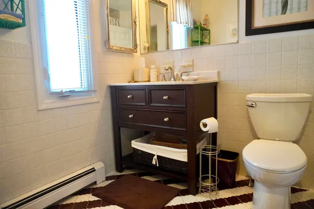 a bathroom with a toilet a sink and a mirror
