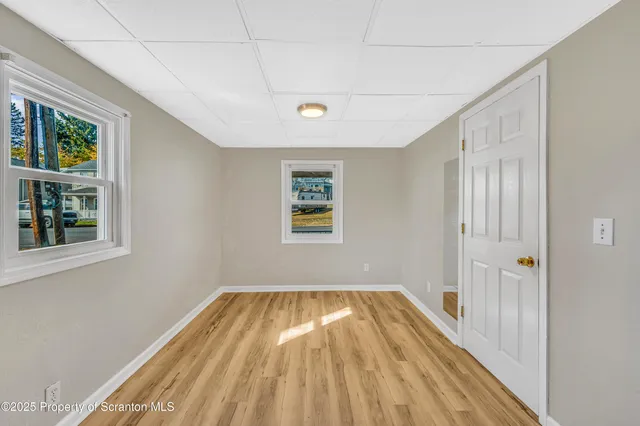 a view of a room with wooden floor and windows
