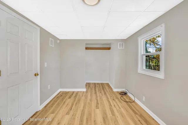 a view of a room with wooden floor and a window