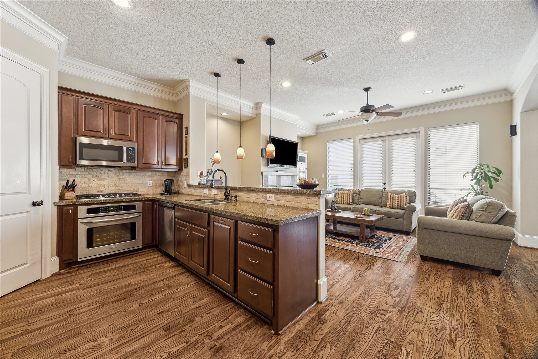 6311 Hamman Street, Unit A Houston, TX 77007 - Photo 13 of 30 a large kitchen with stainless steel appliances granite countertop a stove a sink dishwasher a microwave oven with a dining table and chairs