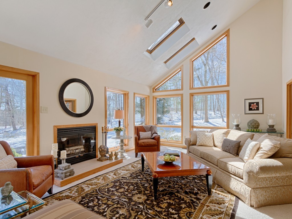14 Skunk Road Merrimac, MA 01860 - Photo 4 of 25 a living room with furniture a rug a fireplace and a large window