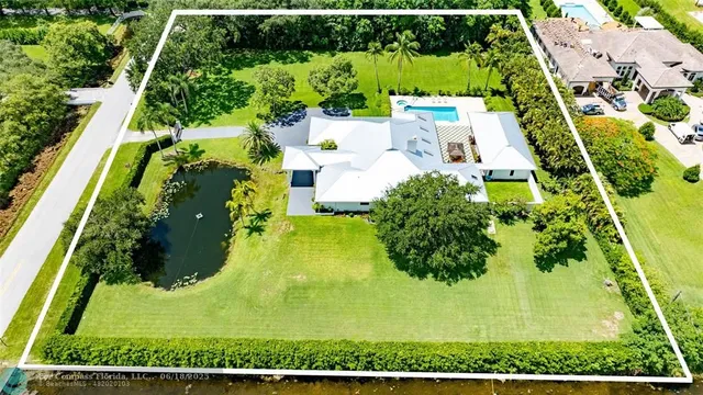 an aerial view of a residential houses with yard