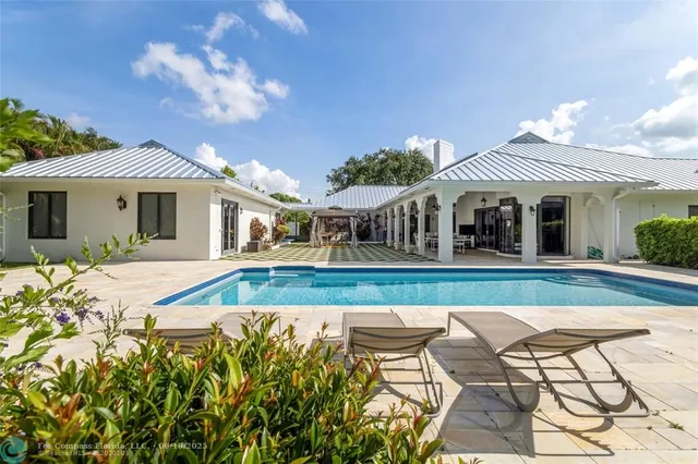 a view of house with swimming pool and porch