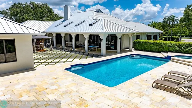 a view of a house with pool and chairs
