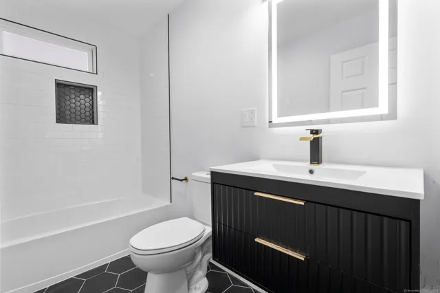 a bathroom with a sink toilet and a mirror