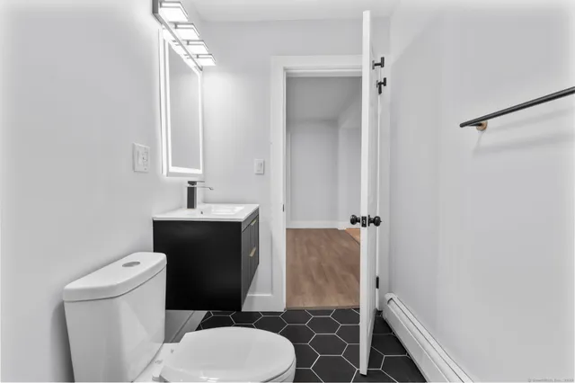 a bathroom with a toilet sink and mirror